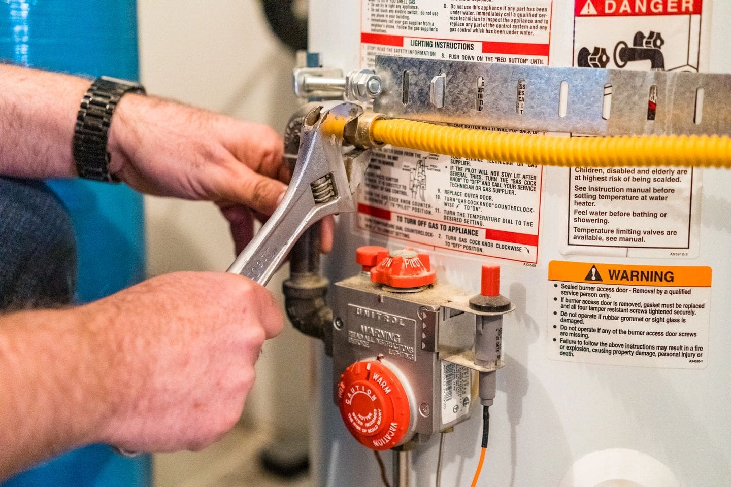 A man is working on the water heater.