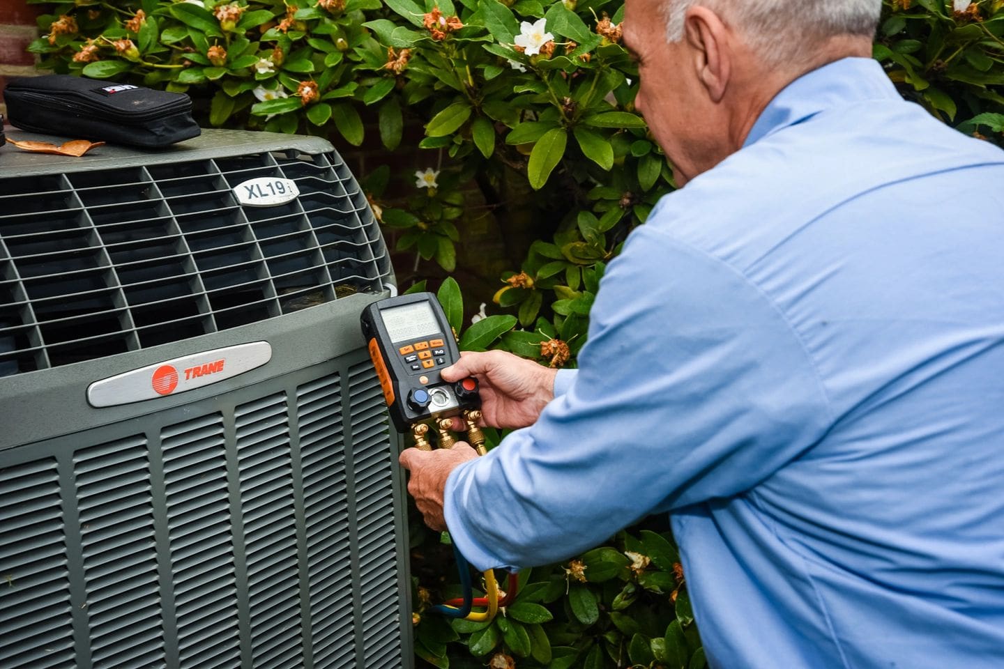 A man is checking the air conditioner