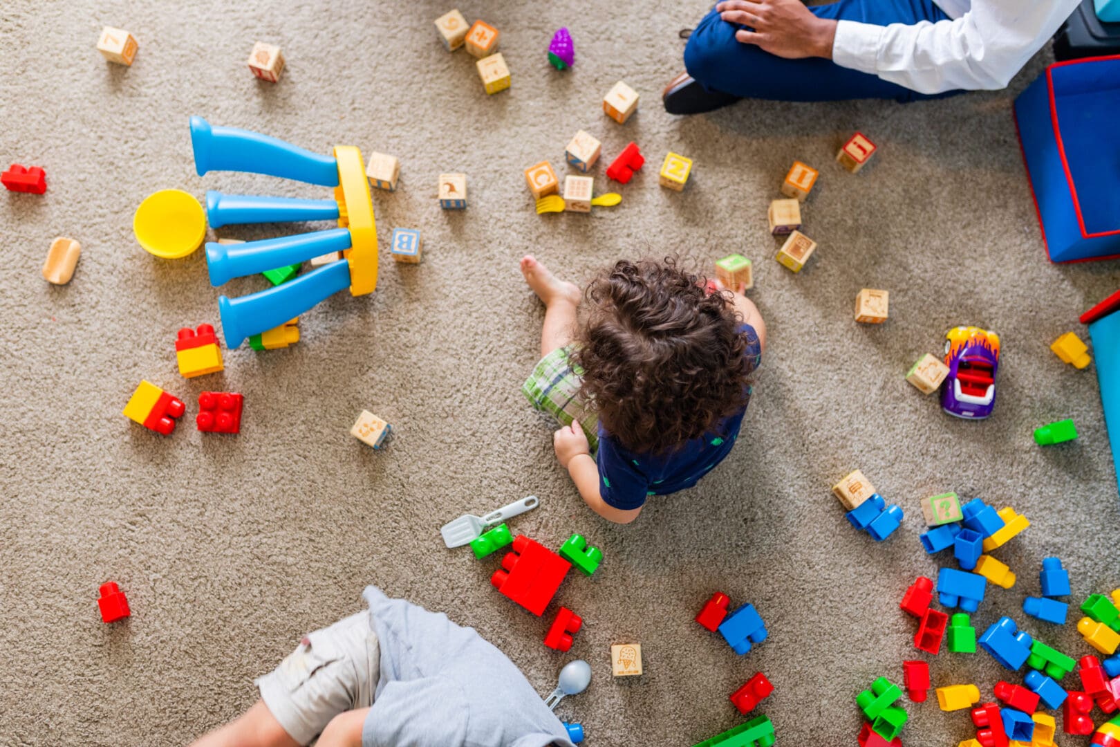 A group of people playing with blocks on the floor.