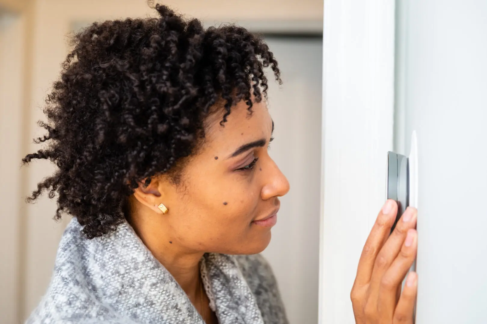 A woman looking at her phone in the mirror.